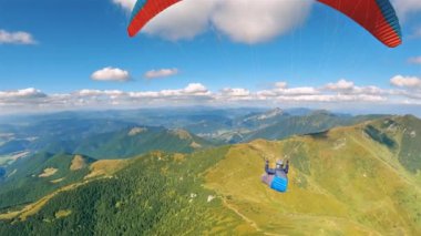 Mavi gökyüzünde tüylü kümülüs bulutları, özgürlük adrenalin macerası paragliding, kamera takip güzel güneşli bir günde yeşil alp dağları üzerinde kırmızı kanat üzerinde uçan termal