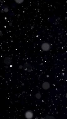 Sinematik dikey bir sahnede kar yavaşça siyah bir arkaplana düşüyor. Sosyal medya örtüşmeleri, kış montajları, meditasyon makaraları veya film tanıtımları için mükemmel