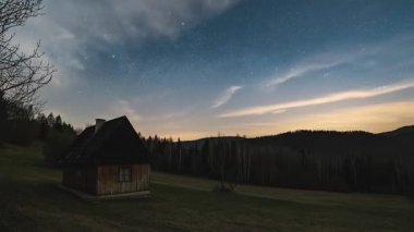 Barışçıl bir astronomi zaman atlaması yıldızlı gece gökyüzünü yıldızlarla dans ederken yakalar ve sessiz bahar doğasıyla buluşan küçük ahşap bir kulübede aurora borealis 'in yumuşak ışığını yakalar.