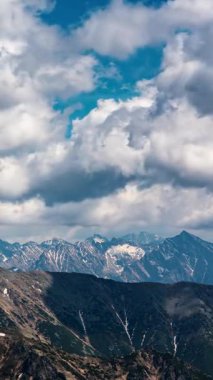 Güneşli bir yaz gününde Alpler 'in üzerinde dramatik bulutların dikey hızlanması. Yürüyüş, macera turizmi, doğa keşfi ve sosyal medya için dağcılık görselleri için ideal.