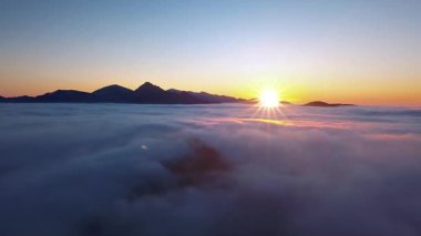 Huzurlu bir sabah Alp Dağları 'nda alçak bulutların üzerinden uçar doğa manzarası güzel bir gündoğumunda. Panoramik Hava Görüntüsü, Pan, İnsansız Hava Aracı 
