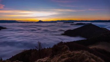 Güneşin doğuşunun güzel ışığı vahşi sisli doğada, sonbahar sabahı dağlık vadide sisli bulutlar ile birlikte. Zaman aşımı, yukarı doğru eğilim, gece gündüz 