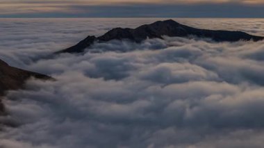 Huzurlu bulutların dağların üzerinden akması akşam ışığında doğa. Sinematik kullanım, açık hava teması ya da ilham verici doğa ve seyahat görüntüleri için harika.. 