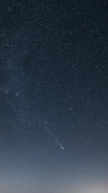 Kuyruklu yıldız Tsuchinshan Atlas 'ın dikey zaman çizelgesi parlayan Samanyolu Galaksisi ile yıldızlı gökyüzünü geçiyor. Bilim, astronomi ve sosyal yaşam için gece gökyüzü gözlemi için mükemmel bir kozmik altyapı.