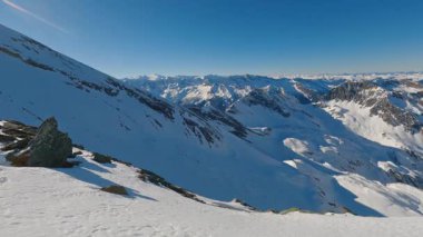 Güneşli kış mevsiminde Alp Dağları 'nın panoramik manzarası. Karla kaplı tepeler, parlak güneş ışığı ve alp yaban hayatı yürüyüş, turizm ve dağ için mükemmel nefes kesici bir doğal manzara yaratır.