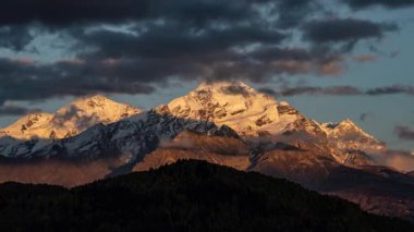 Kafkasya 'daki Tetnuldi Dağı' nda gün batımının en güzel zamanı. Sonbahar mevsiminde karlı tepeler, buzullar ve hızlı hareket eden bulutları gösteriyor. Yürüyüş, turizm ve dağcılık için mükemmel.