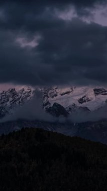 Kafkasya Dağları 'nda karlı Tetnuldi Dağı' nı ortaya çıkaran bulutlarla birlikte büyülü bir güneşin yükselişi. Dramatik gökyüzü ve altın ışık dingin ve sinematik bir dağ manzarası yaratır.. 