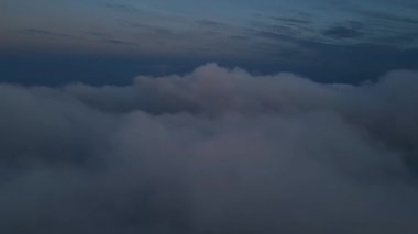 Hızlı hareket eden bulutların havadan görünüşü kasvetli bir akşam gökyüzünü süpürüyor. Rüya gibi, sinematik bulutlar ve karanlık atmosferik hareketler doğa, hava ve hava için dramatik ama barışçıl bir zemin oluşturur.