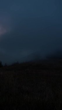 Güneşin doğuşunda dramatik sisli bir dağın dikey hızlanması. Güneşin altın ışığı ormanı ve vadileri sisle kaplıyor. Yürüyüş, açık hava macerası, seyahat, turizm ve doğa projeleri için ideal.