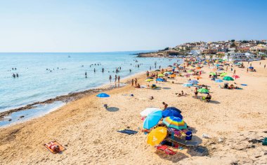 SCICLI, İtalya - 18 Ağustos 2017: Cava D 'Aliga plajı ve Scicli, Sicilya, İtalya' da kimliği belirsiz turistlerin bulunduğu küçük kasaba manzarası