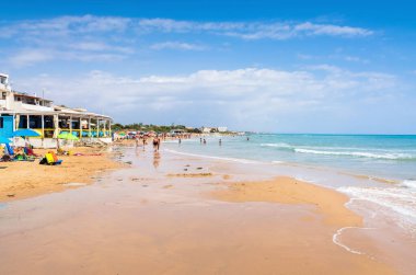 RAGUSA, İtalya - 21 Ağustos 2017: Santa Croce Camerina, Sicilya, İtalya 'da turistlerle Punta Secca plaj manzarası. Kumsal, TV dizisi Müfettiş Montalbano sayesinde ünlü oldu..