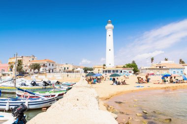 RAGUSA, İtalya - 21 AĞUSTOS 2017: Santa Croce Camerina, Sicilya, İtalya 'da tekne ve deniz feneri manzaralı Punta Secca sahili. Kumsal, TV dizisi Müfettiş Montalbano sayesinde ünlü oldu..