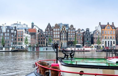 Amsterdam, Hollanda - 12 Haziran 2019: Amstel, Amsterdam, Hollanda 'da tipik Hollanda evleri, kanalları ve dükkanlarıyla gündüz manzarası.