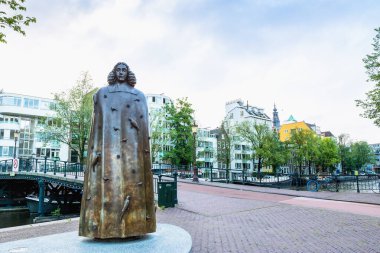 Amsterdam, Netherlands - June 12, 2019: day view of Spinoza monument in on the Zwanenburgwal in Amsterdam, Netherlands. clipart