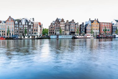 Amsterdam, Hollanda - 12 Haziran 2019: Amstel, Amsterdam, Hollanda 'da tipik Hollandalı evleri, kanalları ve dükkanları ile uzun süreli görünüm.