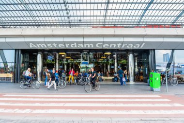 Amsterdam, Hollanda - 14 Haziran 2019: Hollanda 'da Amsterdam, Hollanda tren istasyonu önünde tipik bir Hollandalı motosiklet ve yerlilerle gündüz manzarası.