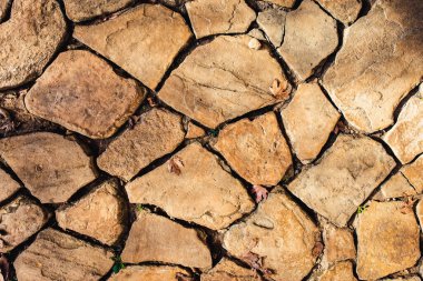 Bej, kahverengi taş yüzey. Taş zeminin dokusu. Yol taşlarla döşenmiş..