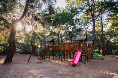 Çevre dostu malzemelerden yapılmış ahşap oyun alanı, açık havada, bir parkta, kozalaklı bir ormanda. Sürdürülebilir kalkınma ve ekoloji kavramı.