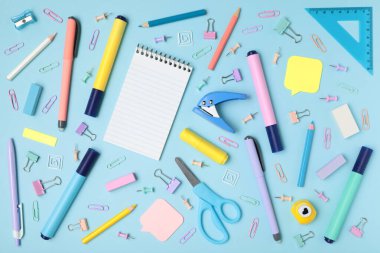 Mavi arka planda okul ve ofis malzemeleri, yakın planda üst görünüm.