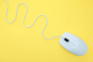 Sarı arka planda beyaz modern bilgisayar faresi. Bilgisayar teknolojisi kavramı
