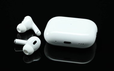 Kiev, Ukraine - June 10, 2023: Headphones Apple Air Pods Pro 2 with Wireless Charging Case on black background. AirPods are wireless Bluetooth earbuds designed by Apple Inc. clipart
