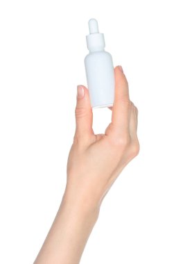 Kadın eli beyaz bir kozmetik şişesi tutuyor, beyaz arka planda kapalı, kozmetik reklamları için bir şablon.