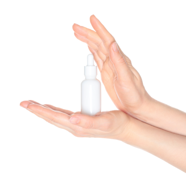 Beyaz bir kozmetik şişesi tutan kadın elleri, beyaz arka planda kapalı, kozmetik reklamları için şablon.