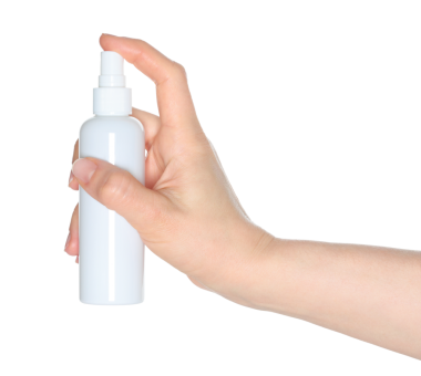 Beyaz sprey şişeyi tutan kadın elleri, şeffaf arka planda kapalı, kozmetik reklamları için şablon.