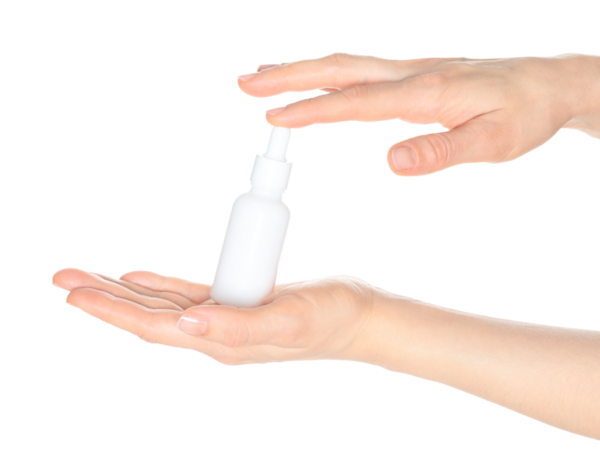 Beyaz bir kozmetik şişesi tutan kadın elleri, şeffaf arka planda kapalı, kozmetik reklamları için şablon.