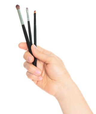 Woman hand holds Cosmetics Brushes, isolated on a transparent background, cosmetics and visage concept