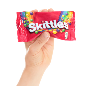 Kyiv, Ukrayna - 02 Ağustos 2024: Şeffaf arkaplanda izole edilmiş Skittles renkli şekerlemelerin el ele tutulması