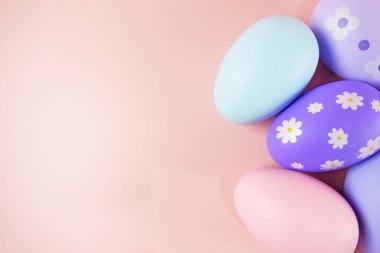 Pembe arka planda renkli paskalya yumurtaları.