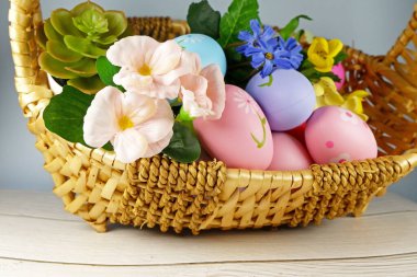  Paskalya yumurtaları ve çiçekler beyaz arka planda sepette. Paskalya konsepti. Boşluğu kopyala