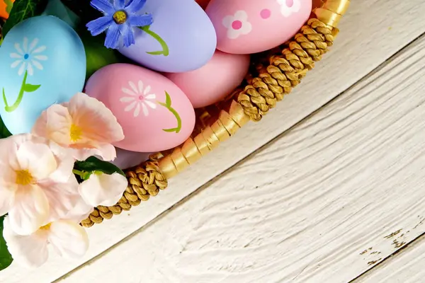  Paskalya yumurtaları ve çiçekler beyaz arka planda sepette. Paskalya konsepti. Boşluğu kopyala