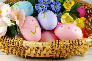  Paskalya yumurtaları ve çiçekler beyaz arka planda sepette. Paskalya konsepti. Boşluğu kopyala