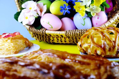 Sepette paskalya yumurtaları ve beyaz arka planda pastalar. Paskalya konsepti