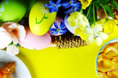 flat lay of  easter eggs and cakes on yellow  background. easter concept. 