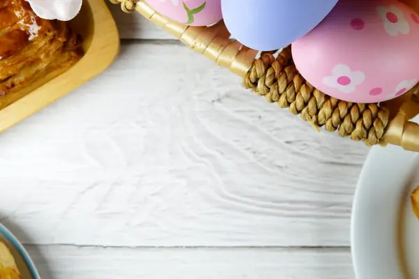 Sepette paskalya yumurtaları ve beyaz arka planda pastalar. Paskalya konsepti