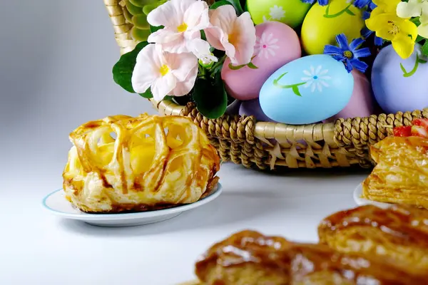 Sepette paskalya yumurtaları ve beyaz arka planda pastalar. Paskalya konsepti