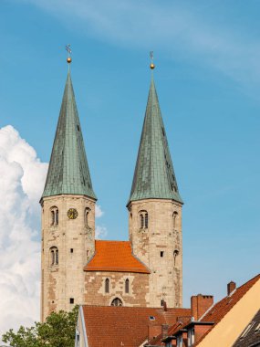 Almanya 'nın Braunschweig şehrinin manzarası. Mavi gökyüzüne karşı St. Martini Kilisesi 'nin iki ortaçağ kulesi. Tarihi binaların elementleriyle dikey fotoğraf.