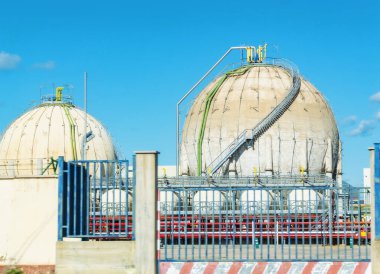 Kimyasal üretim. Yuvarlak tankları olan sanayi bölgesi. Güneşli havada kimyasal fabrika. Endüstriyel arazi. Kimyasal ürünler için baharat kapları. Modern imalat