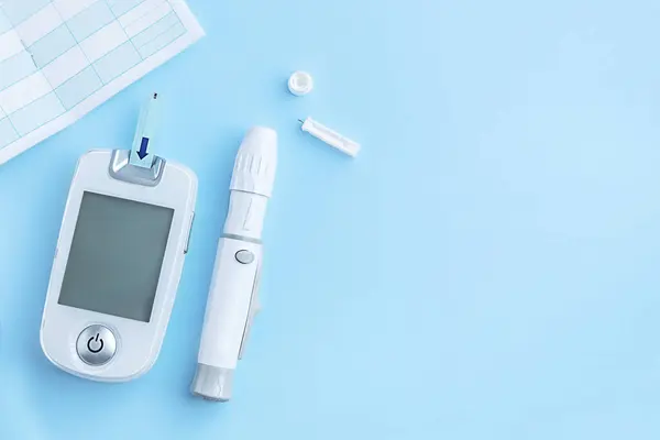 Diyabet Mellitus. Kan şekeri seviyesini kaydetmek için Lancet, glukometre ve defter mavi arka planda. Sağlığınızı kontrol etmek için tıbbi bir cihaz. Yaşam tarzı, insülin bağımlılığı