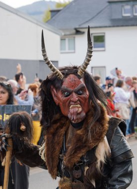 Schierke, Almanya - 30 Nisan 2025. Walpurgis Gece Yürüyüşü 'nde boynuzlu maskeli şeytanın yakın çekimi. Etkinlikte folklordan esinlenilmiş kostümler ve maskeler yer alıyor. Alman gelenekleri