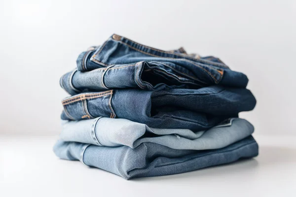 Stack of blue jeans on white background. Clothes for men.