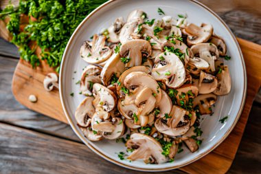 Bir tabak dilimlenmiş mantar ve maydanoz.