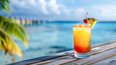 Sahildeki ahşap masada renkli bir kokteyl..