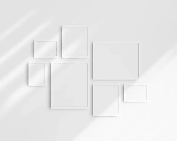 Gallery wall mockup set, 7 white frames. Clean, modern, and minimalist frame mockup. Three horizontal frames, and four vertical frames, 5x7 (5:7), 7x5 (7:5), 8x10 (4:5), 12x15 (4:5), 15x12 (5:4) inches, on a white wall with shadows.