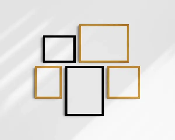 画廊壁面造型 5个黑色和黄色橡木框 现代的框架模型 白色墙壁上有阴影的两个水平框架 两个垂直框架和一个正方形框架 12X16 16X12 8X10 10X8 10X10 图库图片