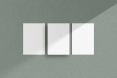 Üç beyaz dikey kağıt maketi, A4 / A5 / A6 el ilanı modeli, kağıt, mektup, davetiye kartı, yeşil arka planda gölgeli.