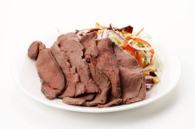 İnce dilimlenmiş soğuk biftek ve beyaz tabakta sebze salatası..